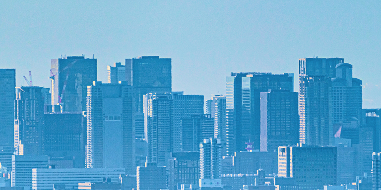 青空の下に広がる高層ビル群の都市景観